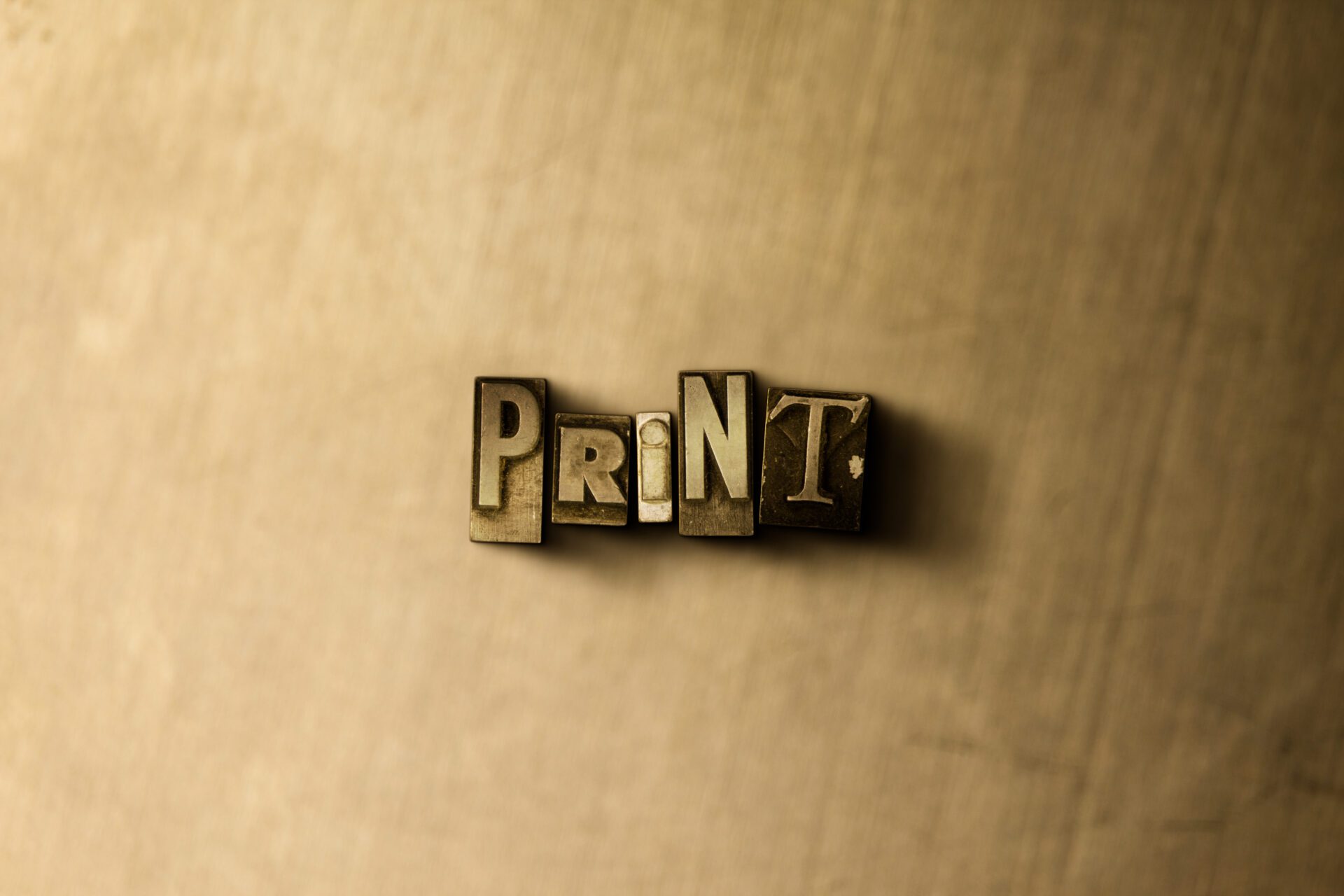 PRINT - close-up of grungy vintage typeset word on metal backdrop